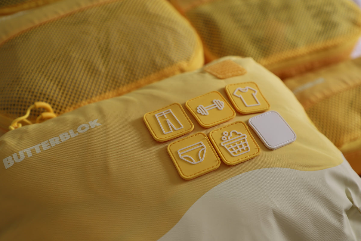 A green Butterblok set stacked on suitcase