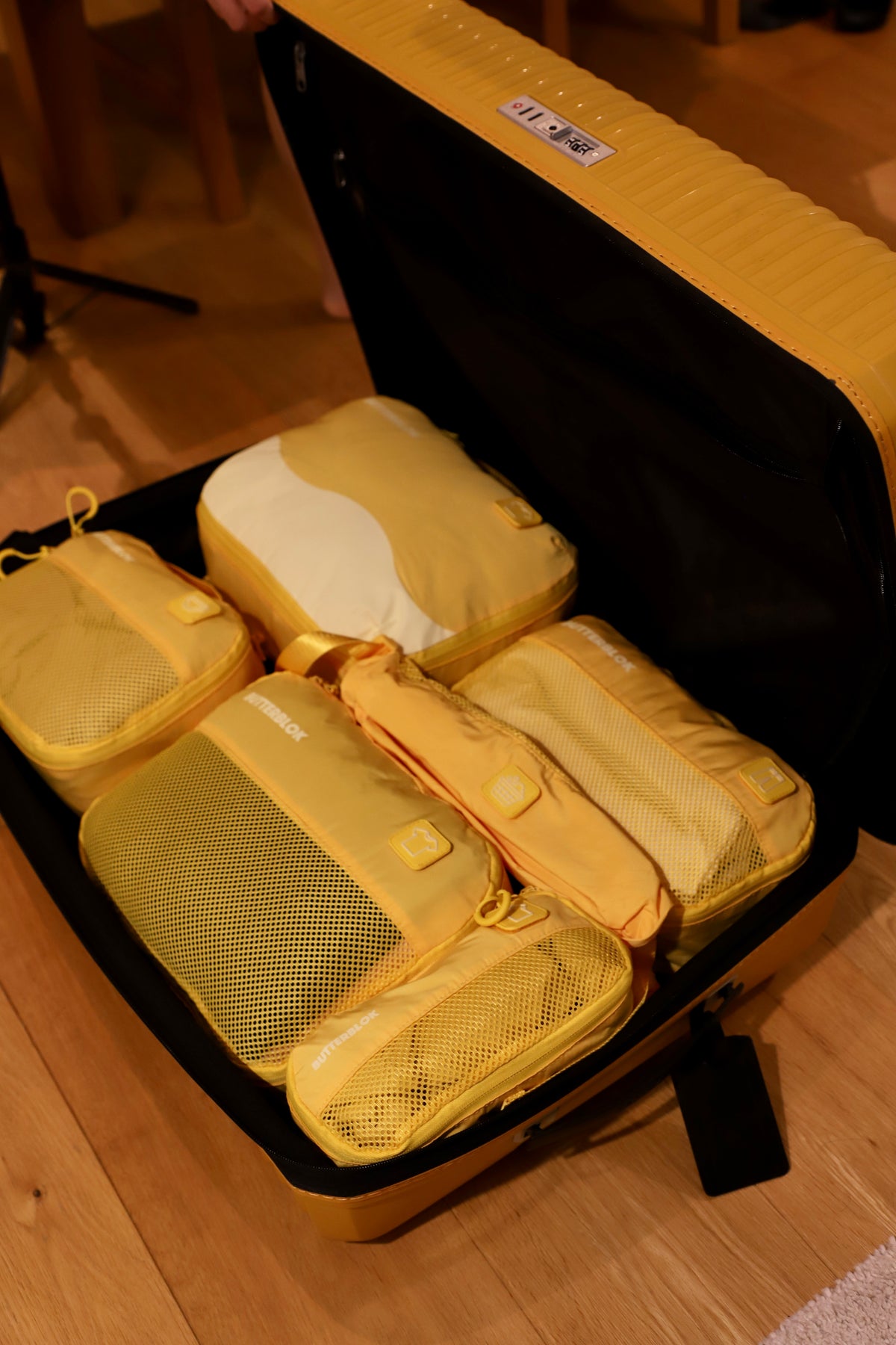 A yellow Butterblok cube on a beach towel, clothes visible through the mesh front