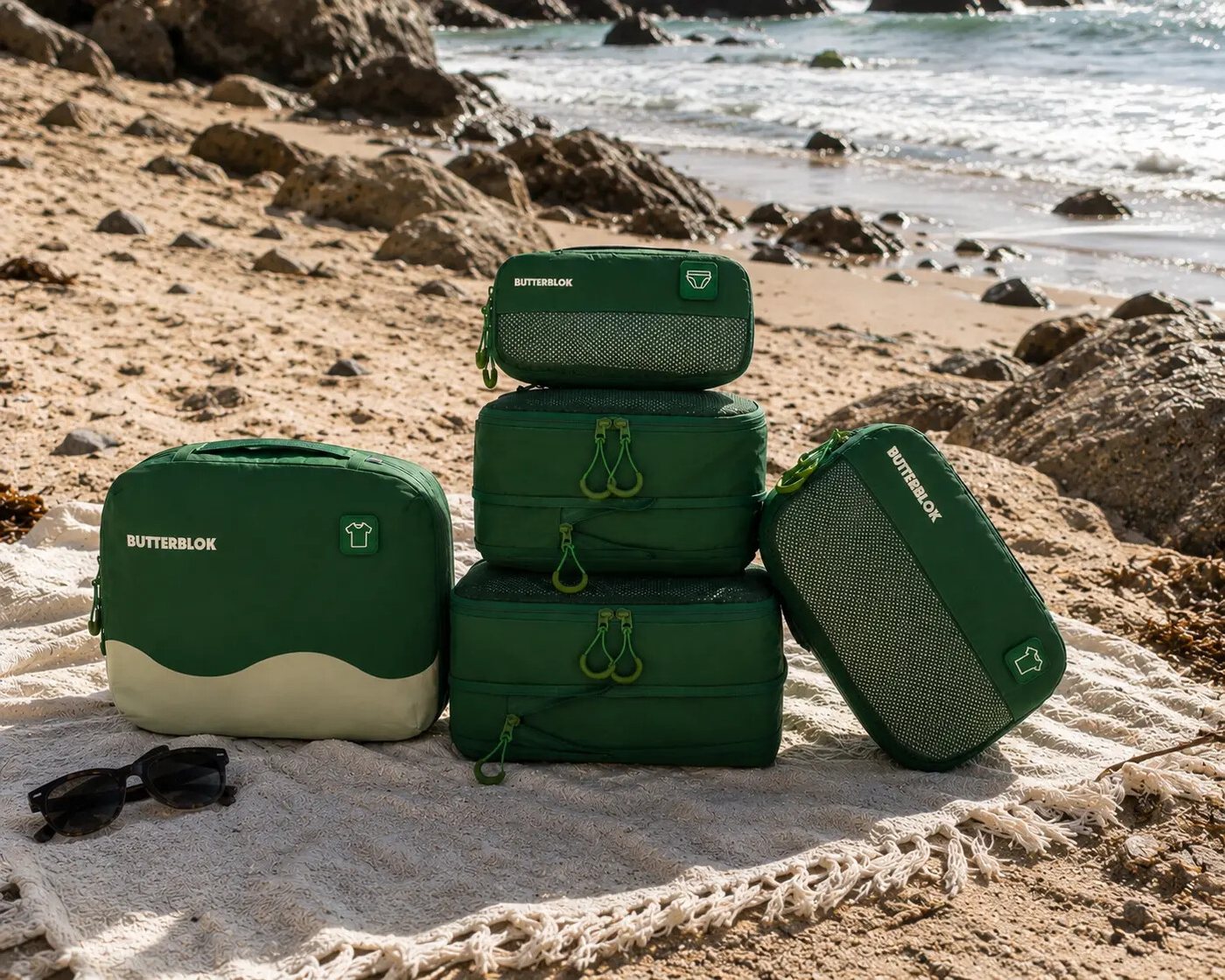 The full green Butterblok set stacked on rocks by the sea